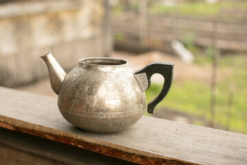 an old metal teapot without a lid. silver color