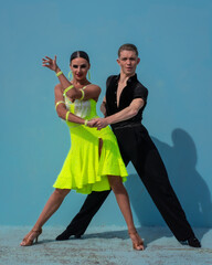 Latin Dance Couple Posing in Front of a Blue Background