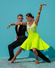 Latin Dance Couple Posing in Front of a Blue Background