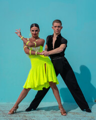 Latin Dance Couple Posing in Front of a Blue Background