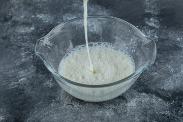 Splashing fresh milk into glass bowl