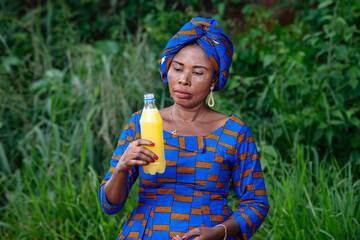 portrait of a beautiful mature african woman with fruit juice.