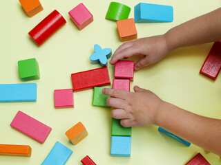 The child plays with wooden colorful blocks. Family vacation with children for the holidays. The child learns shapes and colors.