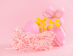 Easter bunny and egg in the nest on a pink background.