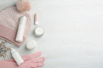 Flat lay composition with different cosmetic products on light table, space for text. Winter care