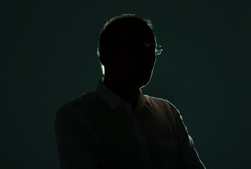Male silhouette with backlit and shadow in glasses