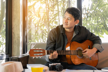 Man is playing guitar, practicing in playing guitar.