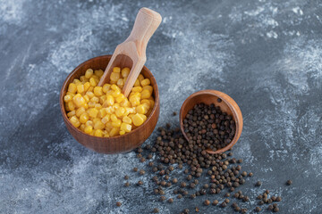 Bowl of sweet corns and grain peppers on marble background