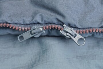 two metal zip on the gray fabric of the jacket on the clothes