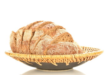 One half of a loaf of sliced, flavored buckwheat bread on a ceramic dish, close-up, isolated on white.