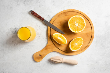 Obraz na płótnie Canvas Sliced fresh oranges with wooden reamer on a marble background