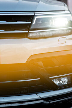 Headlight And Radiator Grille Of A Beautiful Gray Car With Yellow Tint