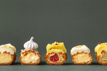 Set of fresh eclairs cut with  butter cream filling and meringue cookies decoration. French pastry...