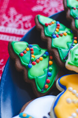 Close-up of beautifully decorated gingerbread Christmas cookies made to look like lit-up Christmas trees on a platter