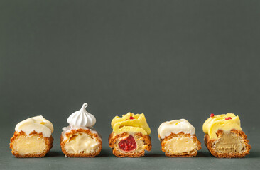 Set of fresh eclairs cut with  butter cream filling and meringue cookies decoration. French pastry...
