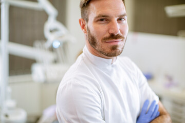Obraz premium Handsome dentist posing in modern dental office