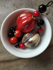 Colorful plastic made bids stack in a white small bowl create a concept.