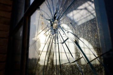 Stoned window with broken glass of an industry.
