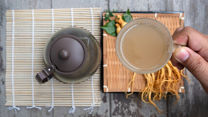 Hand holding a cup of ginseng tea,The concept of healthy drink