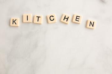 scrabble tiles on the marble countertop spelling the word kitchen