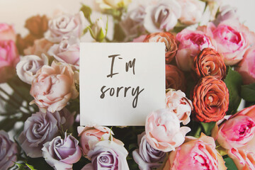 white card for a bouquet with the inscription I am sorry in a bright beautiful bouquet of flowers...