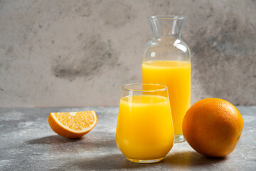 Fototapeta na wymiar A glass cups of orange juice and slices of orange