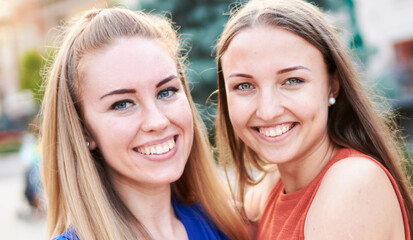 Obraz premium Young happy millennial girls having fun together - University students taking closeup selfie on the streets - Youth and friendship outdoor concept