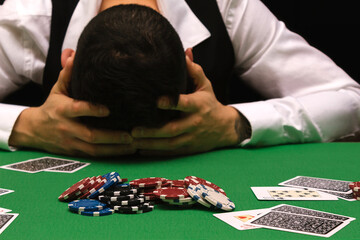 Devastated gambler man losing a lot of money playing poker in casino, gambling addiction. Divorce,...
