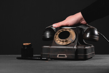 Woman is holding a rotary phone handset close up.