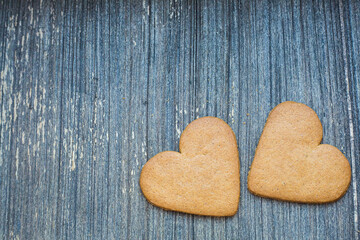 Grey wooden aged background with ginger bread biscuits. Saint valentines frame with copy space. Love and wedding invitation wallpaper. Sweetheart composition. Be my Valentine. Togetherness