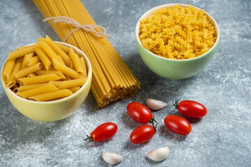 Different types of raw pasta with vegetables