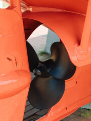 Black propeller on a red boat © Marianna