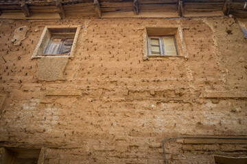 windows of an antique rustic house made of clay 