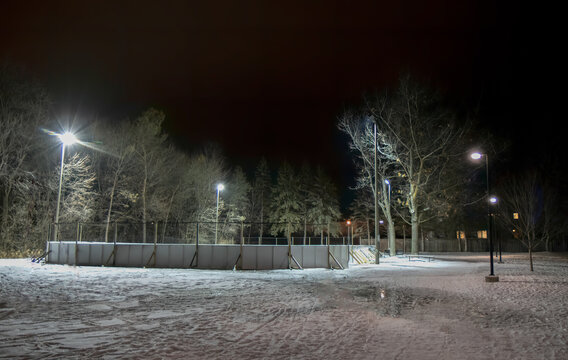 Deserted outdoor hockey rink in urban park at night closed due to COVID-19