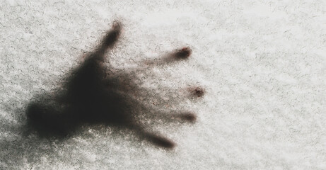 Handprints on the snow-covered glass