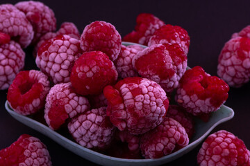 Frozen Raspberries in a Bowl placed on a black background