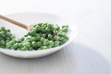 green peas in a white plate on a white background