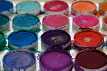 Abstract view of watercolor paint cakes in a palette.