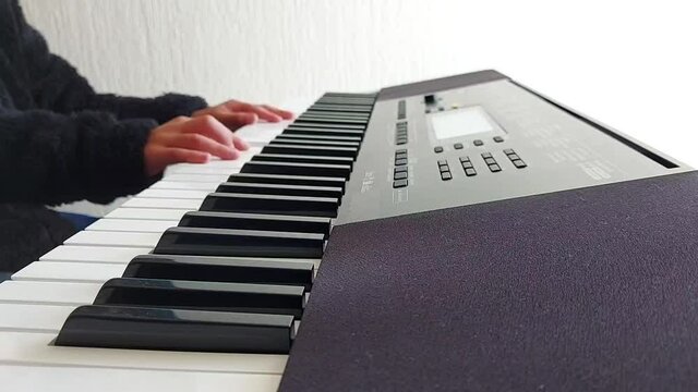 Niños practicando en su clase de teclado musical