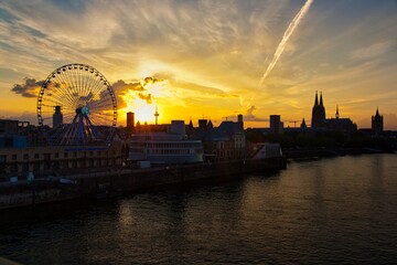 Riesenrad im Sonnenuntergang vor Kölner Skyline