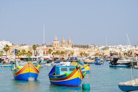 Maltese boats float in the harbor of Marsaxlokk, Malta. the fishing boats are decorated with the eye of Osiris to keep the fishers safe at sea.