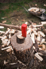 Red ax stuck in the wood. Chopping wood into a log.