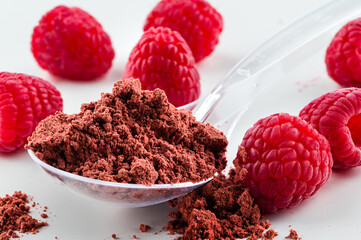A pile of instant raspberry juice powder concentrate on a white background. dry raspberry super...