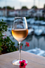 Tasting of local rose wine in summer with sail boats haven of Port Grimaud on background, Provence, France