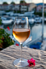 Tasting of local rose wine in summer with sail boats haven of Port Grimaud on background, Provence, France