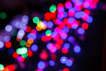 Blurry Multi-colored lights of the hexagon ("nuts") in the bokeh - a garland, Christmas decorations in defocus.