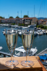Summer party with sparkling champagne wine and sail boats haven of Port Grimaud on background, Provence, France