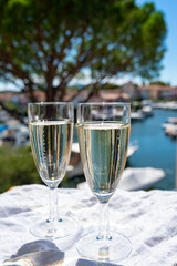 Summer party with sparkling champagne wine and sail boats haven of Port Grimaud on background, Provence, France