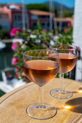Tasting of local rose wine in summer with sail boats haven of Port Grimaud on background, Provence, France