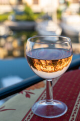 Drinking of local rose wine in summer with sail boats haven of Port Grimaud on background, Provence, France